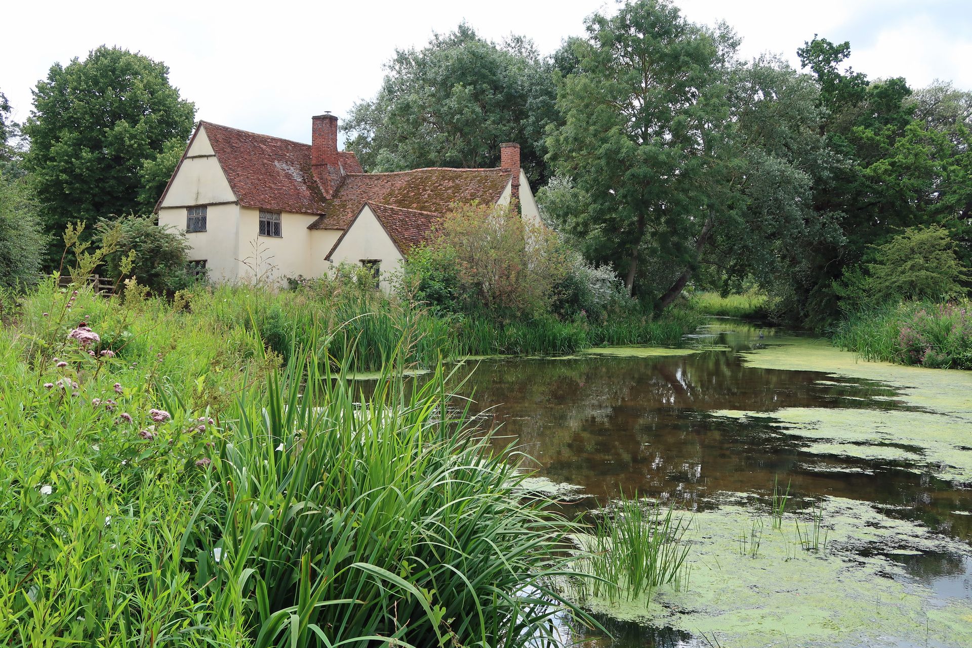 Vue de Flatford Mill à travers l’étang du moulin jusqu’au chalet de Willy Lott et à la rivière Stour © Getty Images